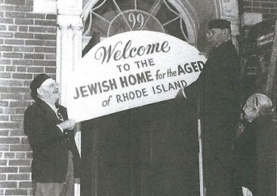 Men hanging the sign for the Jewish Home building