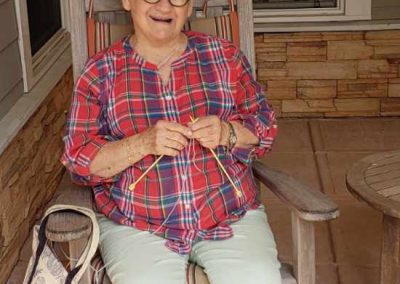 A woman sitting on the porch and knitting