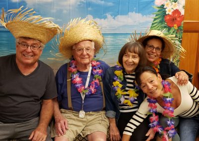 A group of people wearing tropical style straw hats and smiling